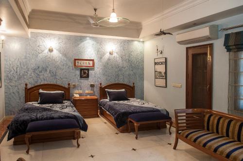 1 dormitorio con 2 camas y sofá en Villa 33 en Nueva Delhi