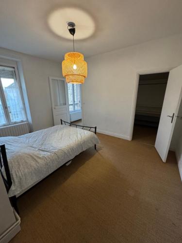 une chambre avec un lit et un lustre dans l'établissement 2 bedroom Apartment Reims, à Reims