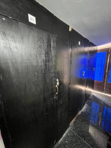 a black wall with a door in a room at Sobrat One in Phnom Penh