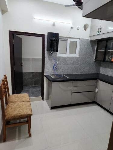 a kitchen with a counter and a chair and a sink at Just Launched Cute Studio 2 BHK Flats in Kondapur Near Botanical Garden & Sarath City Capital Mall in Kondapur