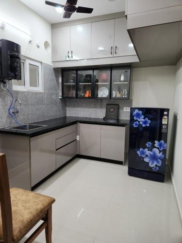 a kitchen with a refrigerator with blue flowers on it at Just Launched Cute Studio 2 BHK Flats in Kondapur Near Botanical Garden & Sarath City Capital Mall in Kondapur