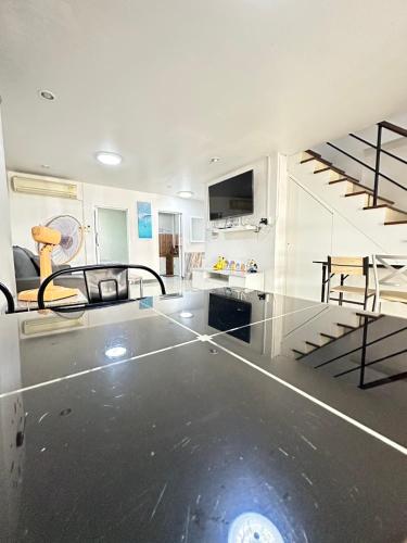 a living room with a staircase in the middle at NB bangsaen house KL2 in Ban Puk (2)