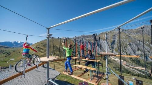 a group of people on a zip line in the mountains at Chalet Mittaghorn in Adelboden