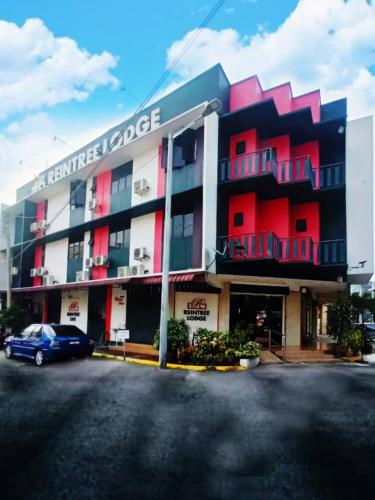 a building with a car parked in front of it at Reintree Lodge Hotel in Ipoh