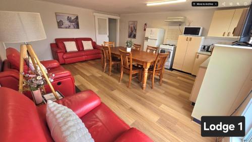 a living room with a red couch and a table at High View Family Cottages in Warrnambool