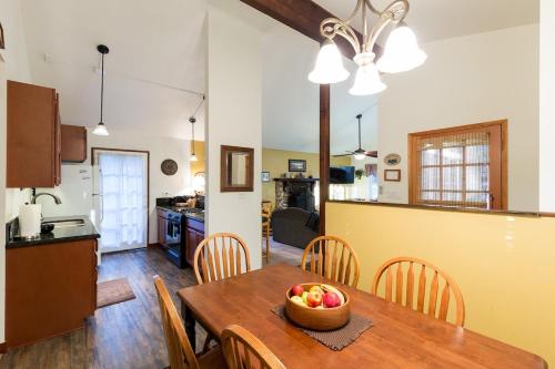 eine Küche und ein Esszimmer mit einem Tisch und einer Obstschale in der Unterkunft Spacious cozy chalet huge deck over seasonal creek in Big Bear City Airport