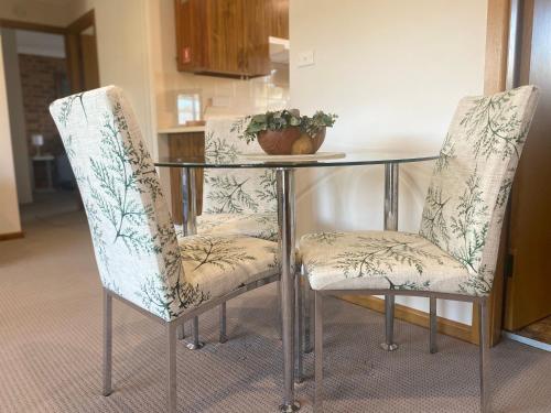 two chairs and a glass table with a plant on it at Stay on Lachlan in Cowra
