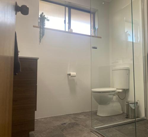 a bathroom with a toilet and a glass shower at Stay on Lachlan in Cowra