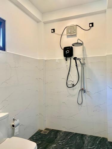 a bathroom with a toilet and a camera on the wall at The Elite in Udawalawe