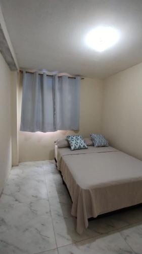 a bedroom with a large bed and a window at casa de campo Chalé bela vista in Tijucas