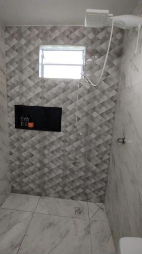 a bathroom with a shower with a window on the wall at casa de campo Chalé bela vista in Tijucas