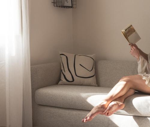 a woman sitting on a couch reading a book at Cortona Skyline Retreat in Cortona