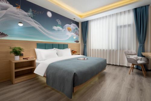 a bedroom with a bed and a painting on the wall at Lansheng Lucky Light Luxury Smart B&B in Lijiang