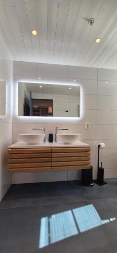 a bathroom with two sinks and a mirror at Andøy Vest Rorbuer Reine in Reine