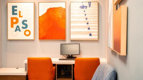 a desk with two orange chairs and a computer on it at Holiday Inn Express Hotel & Suites CD. Juarez - Las Misiones by IHG in Ciudad Juárez