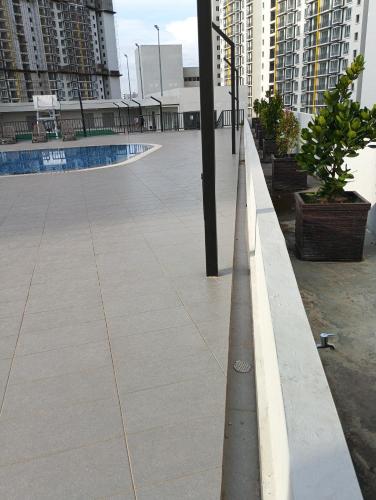 an empty sidewalk in a city with tall buildings at mazya homestay in Melaka