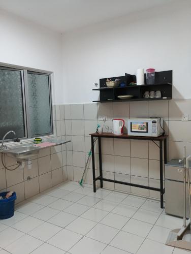 a bathroom with a sink and a table with a mop at mazya homestay in Melaka