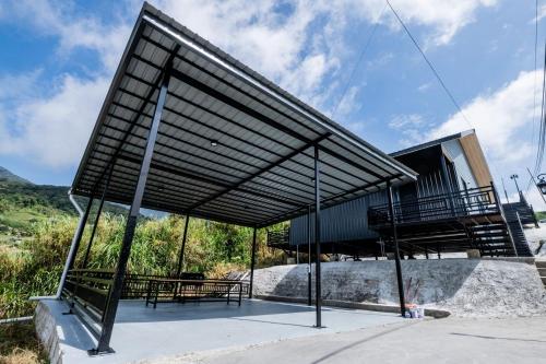 a pavilion with tables and benches in front of a building at 929 Villa, kundasang in Kundasang