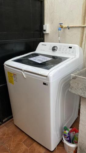 a white washing machine sitting next to a wall at Departamento enteró en Mayorazgo in El Gallinero