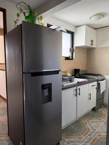 a large stainless steel refrigerator in a kitchen at Departamento enteró en Mayorazgo in El Gallinero