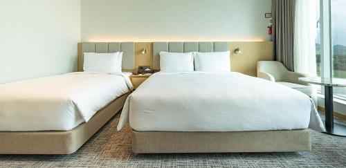 a hotel room with two beds and a window at Stanford hotel Andong in Andong