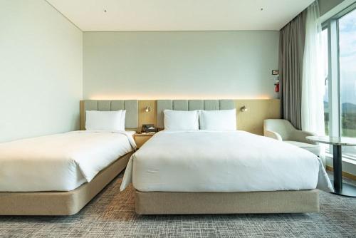 a hotel room with two beds and a window at Stanford hotel Andong in Andong