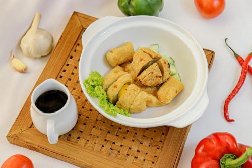 a plate of food on a cutting board with a bowl of food at Grand Keisha Yogyakarta in Yogyakarta