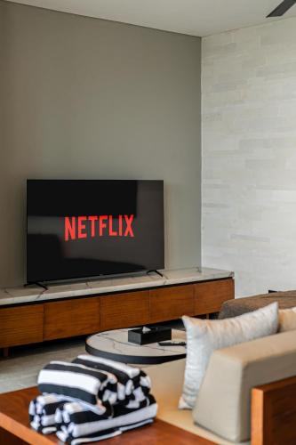 a television with a netflix sign on a wall at Body Factory Lifestyle Residence in Canggu