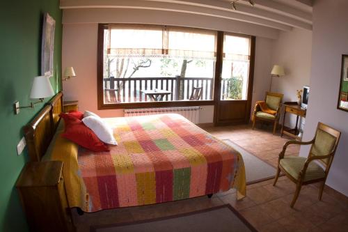 een slaapkamer met een bed met een kleurrijke deken en een raam bij Casa Rural Higeralde in Hondarribia