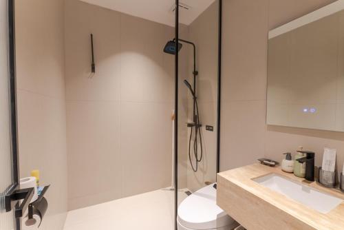 a bathroom with a shower and a toilet and a sink at Eden Yard Boutique Hotel and Experiences in Xianghu