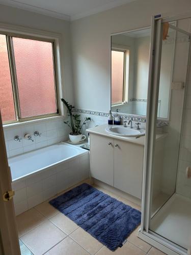 a bathroom with a tub and a sink and a mirror at Cosy and convenient in Lynbrook in Lyndhurst