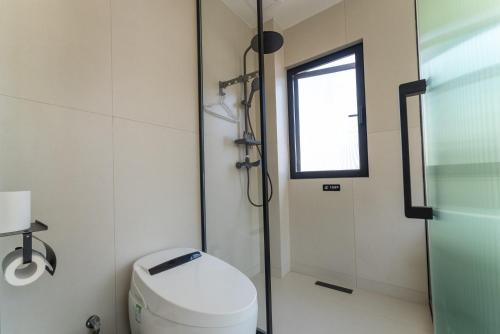 a bathroom with a toilet and a window and a shower at Eden Yard Boutique Hotel and Experiences in Xianghu