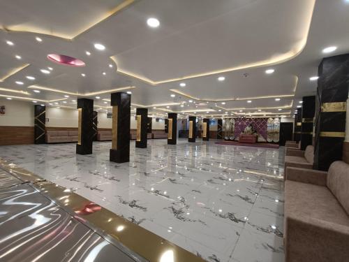 a lobby with a marble floor and black pillars at Swet Palash Resort in Purulia