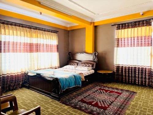 a bedroom with a bed with curtains and a rug at Panauti Homestay in Panauti
