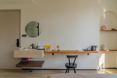 a bathroom with a sink and a stool at Eden Yard Boutique Hotel and Experiences in Xianghu