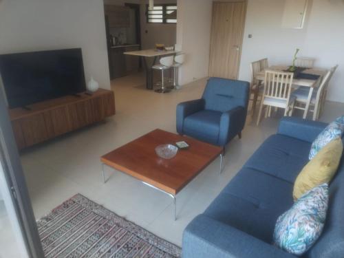 a living room with a blue couch and a television at Sky Sunrise two rooms apartment in Moka
