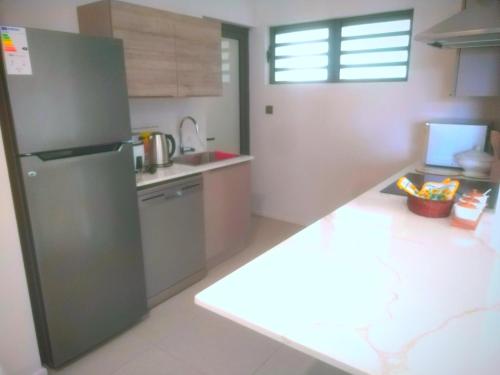 a kitchen with a refrigerator and a counter top at Sky Sunrise two rooms apartment in Moka