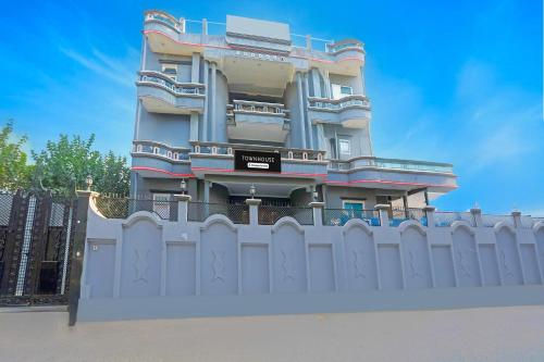a building with a white fence in front of it at Super Townhouse Vijay Khand Gomti Nagar in Lucknow