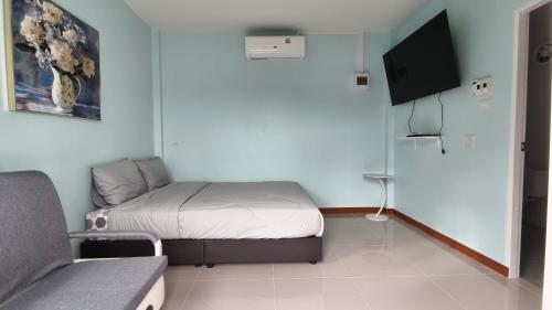 a small bedroom with a bed and a couch at โซพราว เขาค้อ So Proud Khaokho in Khao Kho