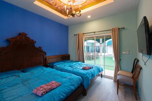 a blue bedroom with two beds and a window at Paris De Floor Khaoyai in Pak Chong