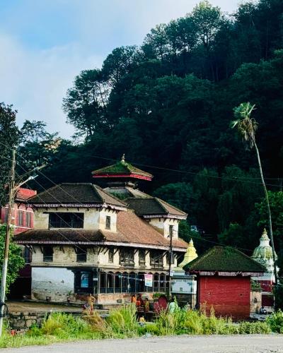 an old building with a mountain in the background at Panauti Homestay in Panauti
