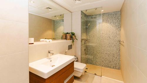 a bathroom with a sink and a toilet and a shower at Studio In Al Hadeel Hosted By Voyage in Abu Dhabi