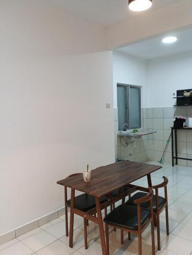 a wooden table and chairs in a room at mazya homestay in Melaka