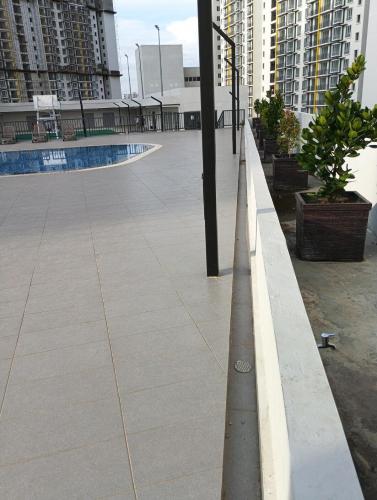 an empty sidewalk in a city with tall buildings at mazya homestay in Melaka