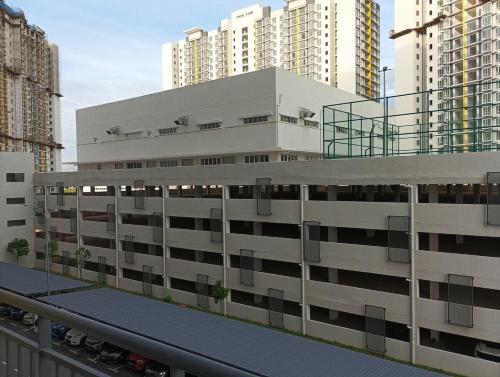 a large white building in a city with tall buildings at mazya homestay in Melaka
