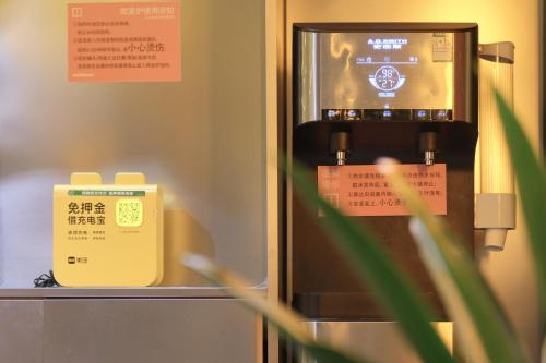 a vending machine with a sign in front of it at wohkoon Youth Hostel Sanlitun Taikoo Li Branch in Beijing