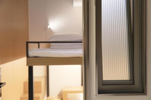 a room with a bunk bed and a mirror at wohkoon Youth Hostel Sanlitun Taikoo Li Branch in Beijing
