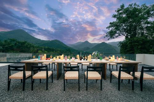 a dining table and chairs with a view of mountains at Wild Persimmon Manor Cove Mist Healing Hot Spring in Anji