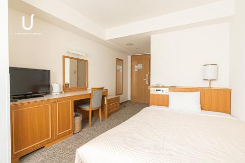 a hotel room with a bed and a desk and a television at Forest Hongo by unito in Tokyo