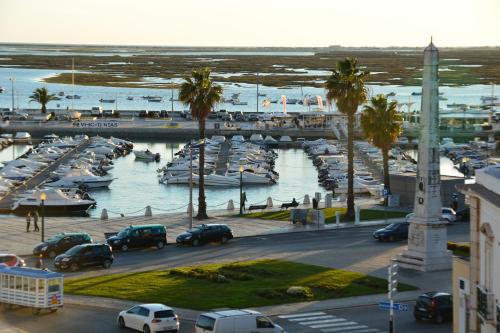a marina with boats and cars parked in the water at Residencial A Doca in Faro